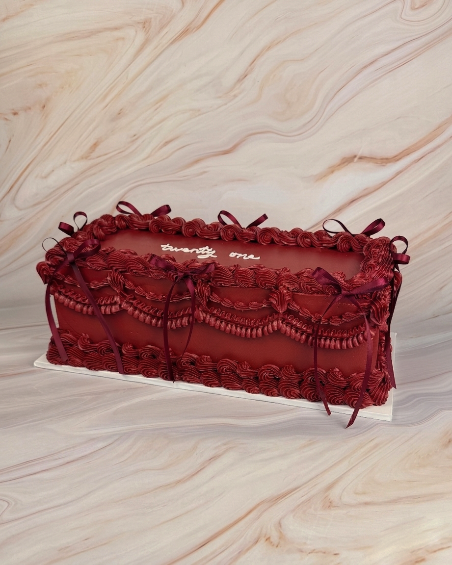 Decorative  burgundy vintage cake with intricate designs including burgundy ribbons